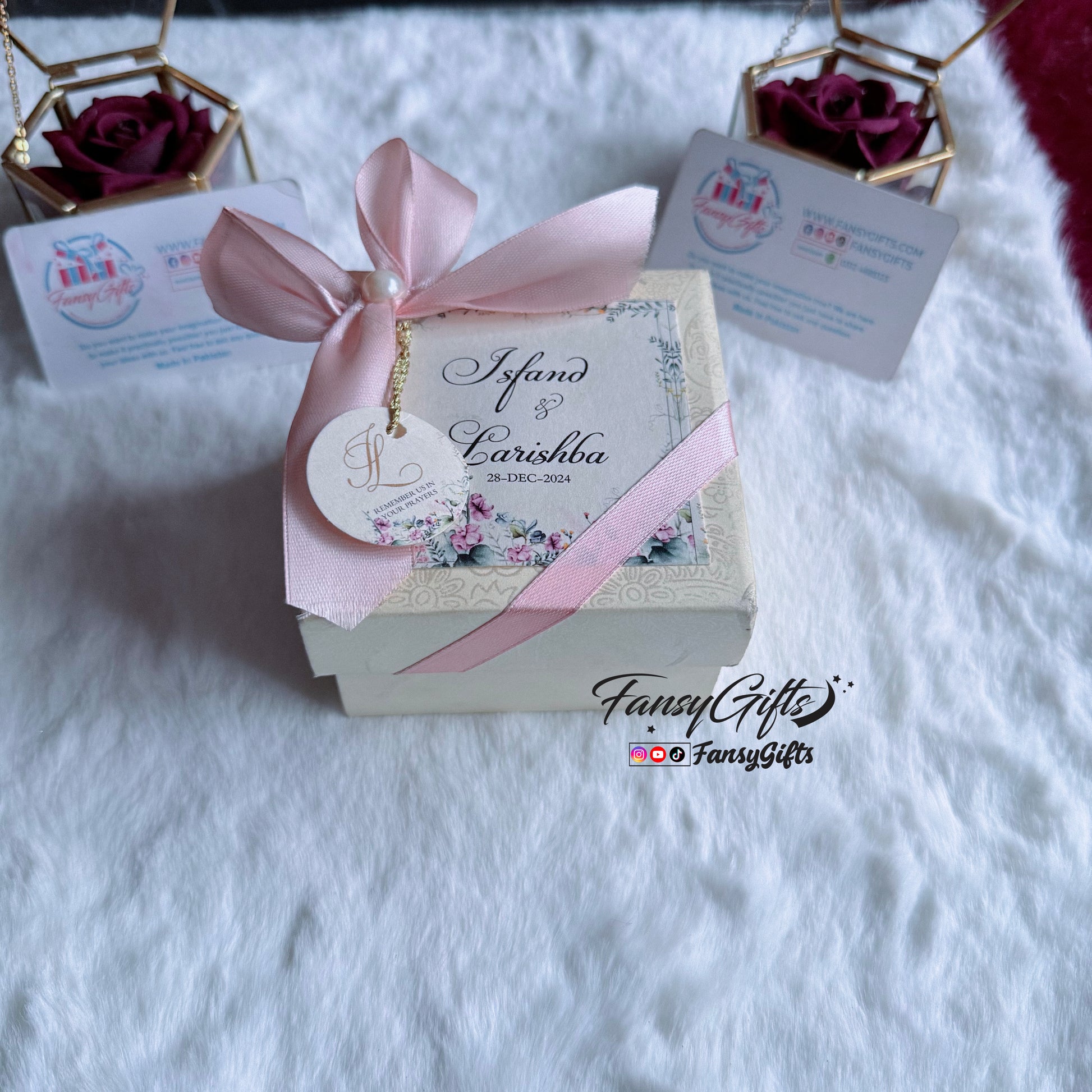 Decorative gift box with a pink ribbon and personalized tag on a white surface, branded 'Fancy Gifts'.